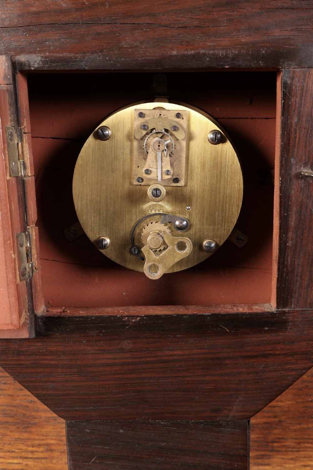 A Regency dark rosewood mantel clock with intricate brass inlay, an octagonal dial surround, and an equestrian brass scene on the base plinth. View IX