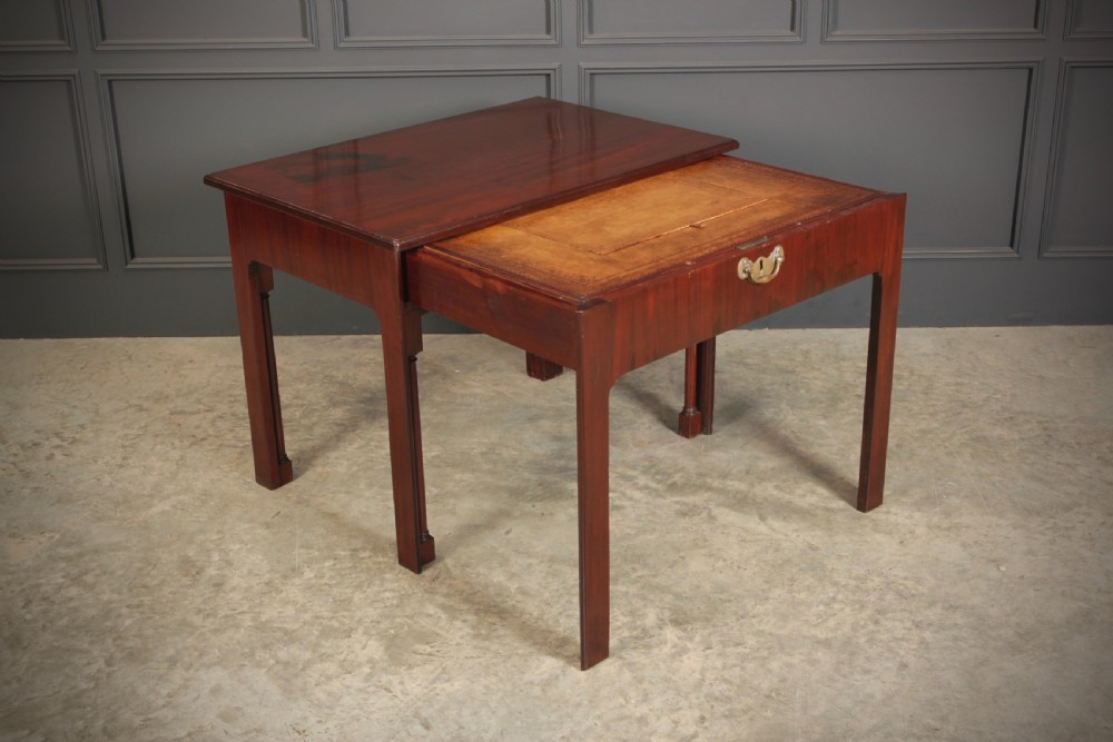 A Georgian mahogany architects table featuring a sliding front drawer with an inlaid leather writing top and square support legs.