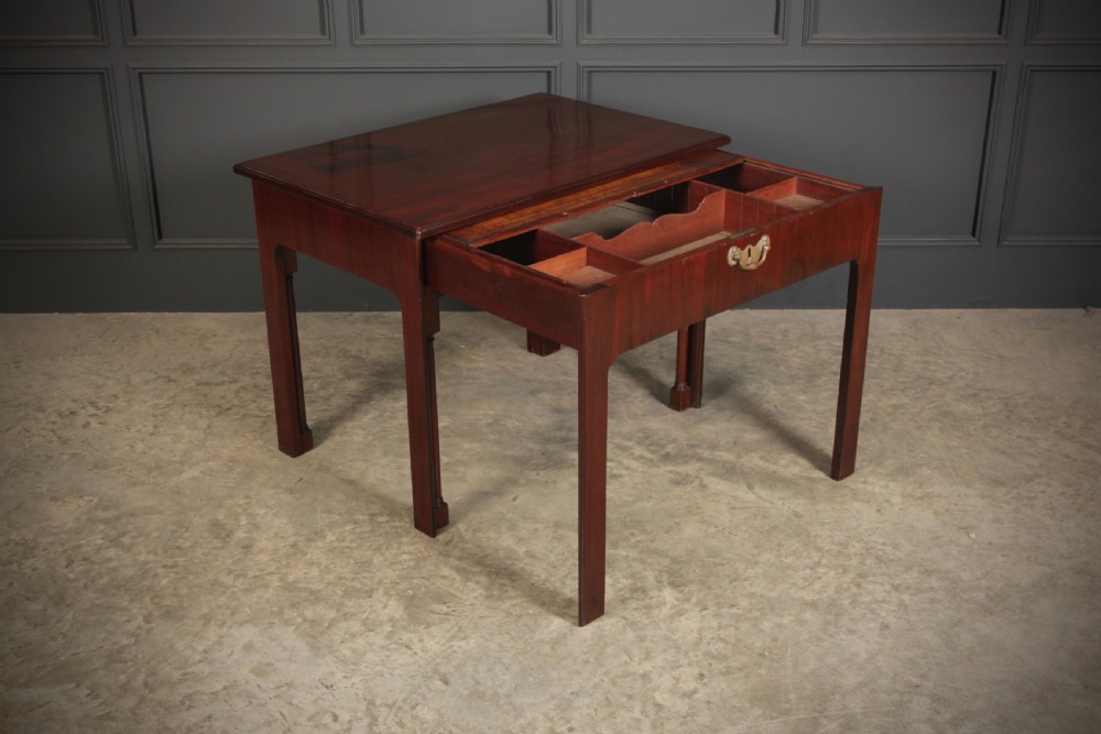A Georgian mahogany architects table featuring a sliding front drawer with an inlaid leather writing top and square support legs. View V