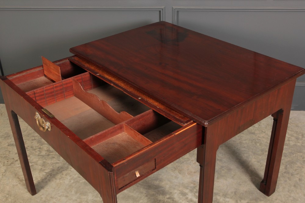A Georgian mahogany architects table featuring a sliding front drawer with an inlaid leather writing top and square support legs. View VI