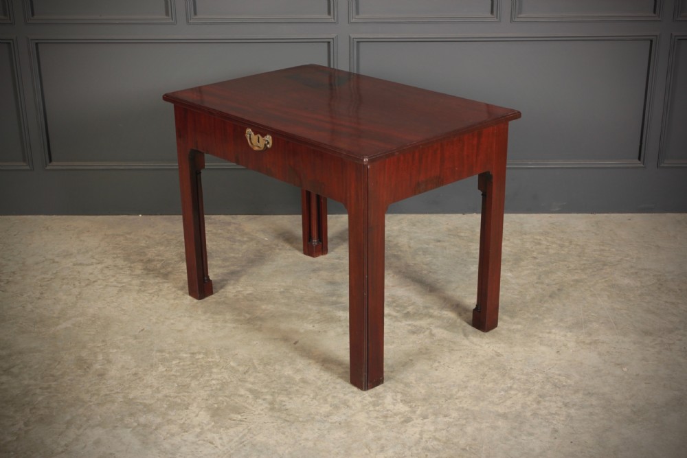A Georgian mahogany architects table featuring a sliding front drawer with an inlaid leather writing top and square support legs. View X
