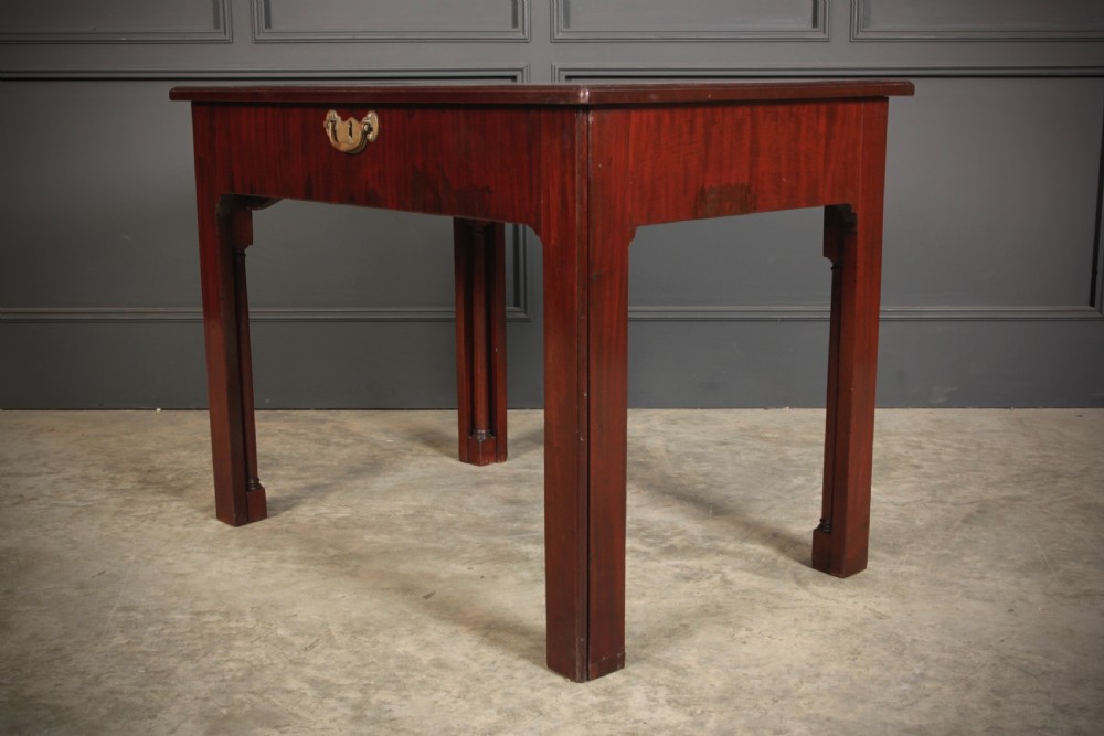 A Georgian mahogany architects table featuring a sliding front drawer with an inlaid leather writing top and square support legs. View XI