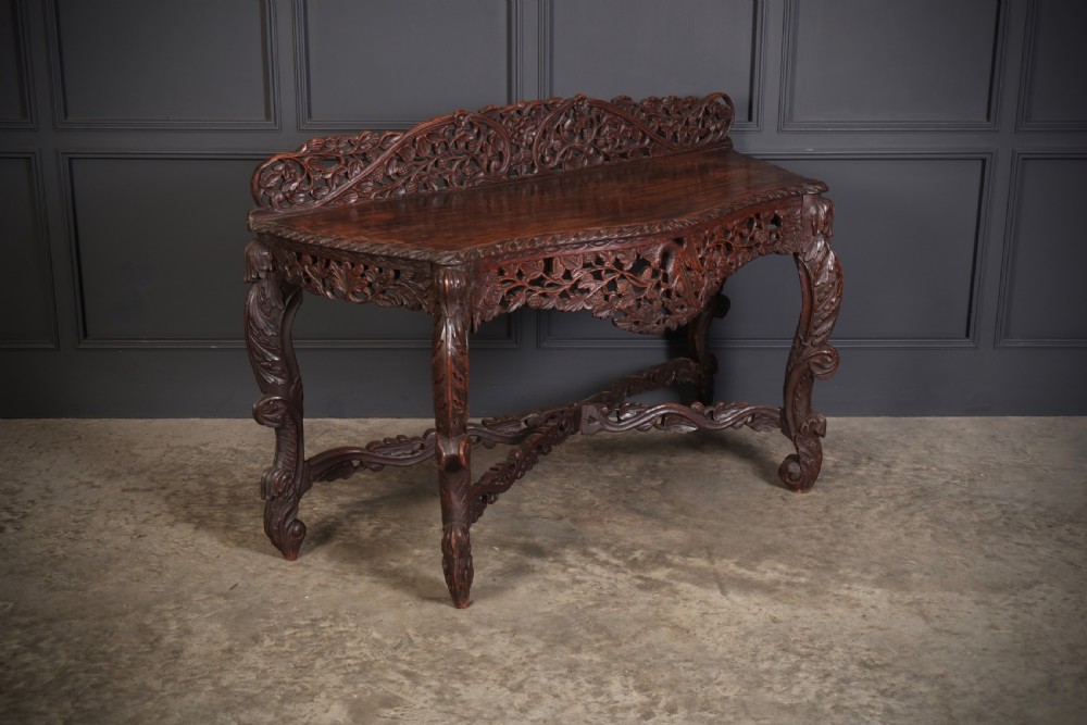 A 19th-century dark hardwood console table featuring pierced foliate carving along the apron, gallery back, and curved legs. View V