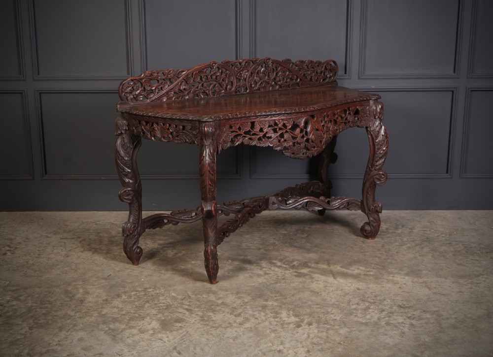 A 19th-century dark hardwood console table featuring pierced foliate carving along the apron, gallery back, and curved legs.
