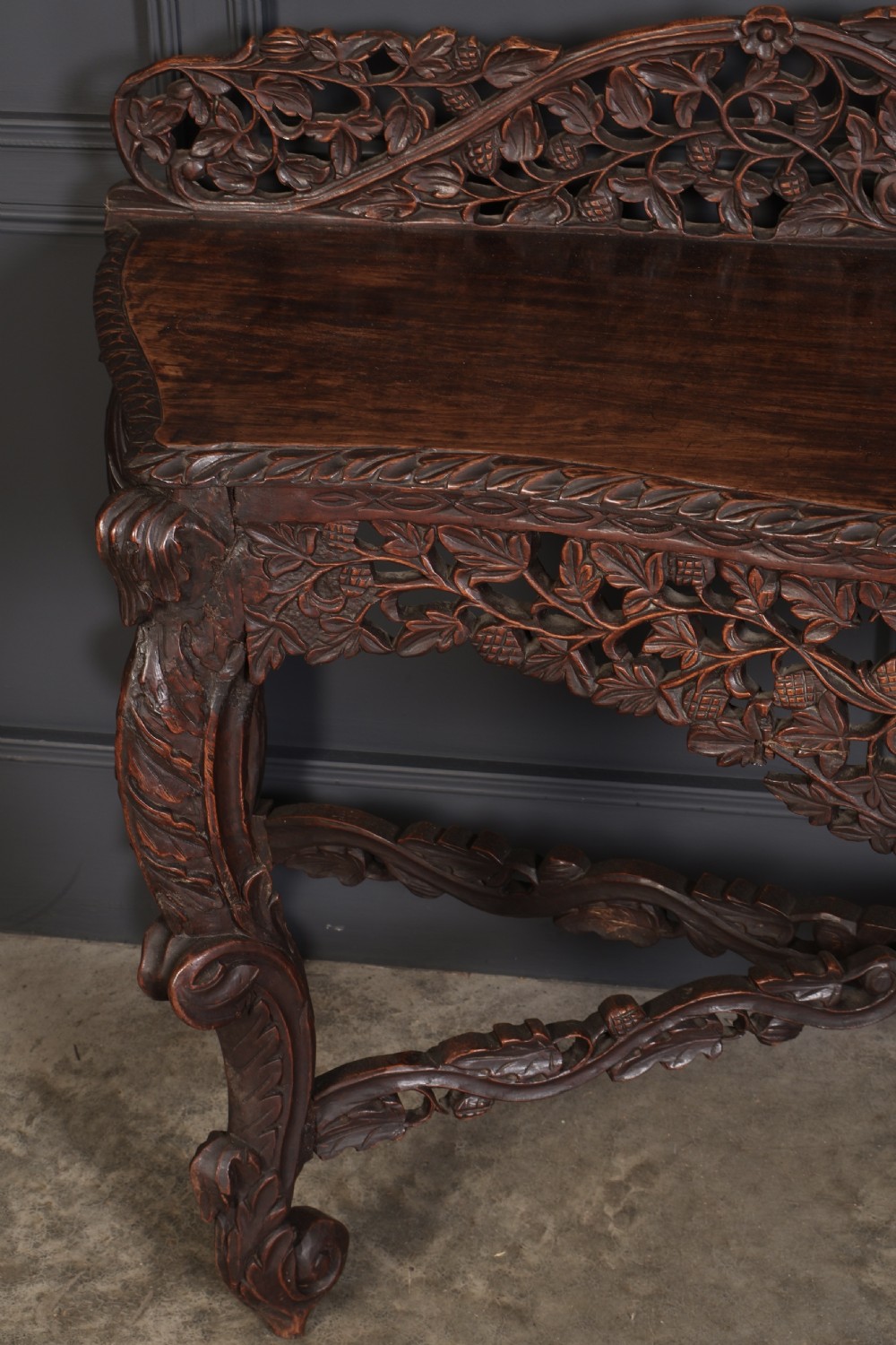 A 19th-century dark hardwood console table featuring pierced foliate carving along the apron, gallery back, and curved legs. View VI