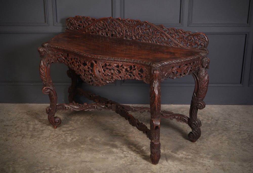 A 19th-century dark hardwood console table featuring pierced foliate carving along the apron, gallery back, and curved legs. View VIII