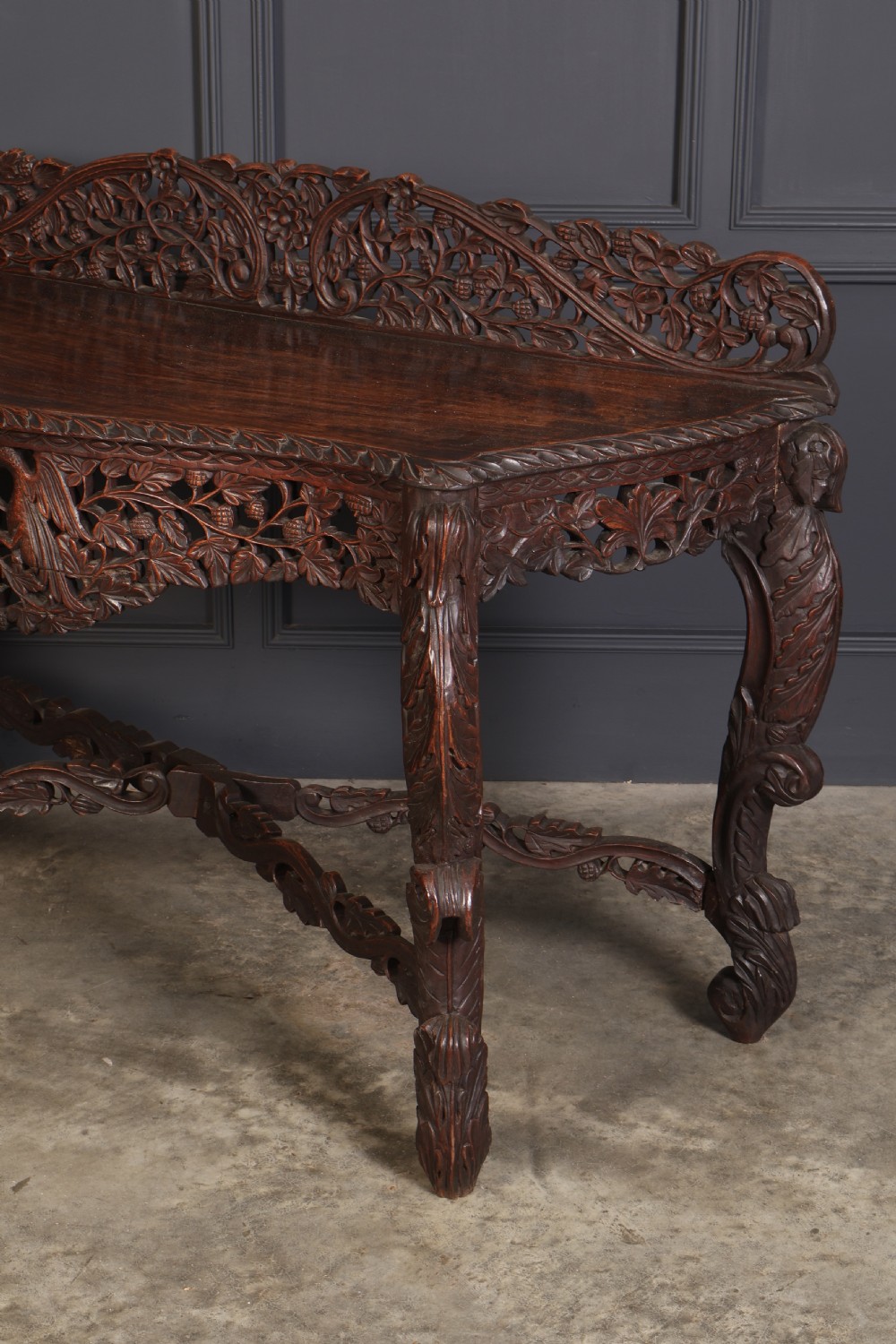 A 19th-century dark hardwood console table featuring pierced foliate carving along the apron, gallery back, and curved legs. View X