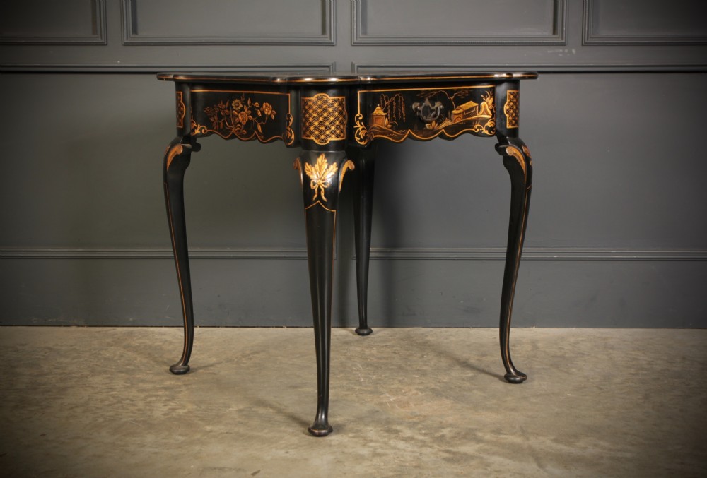 A black lacquered occasional table with gilded Chinoiserie scenes, a scalloped rim, and cabriole legs. View II
