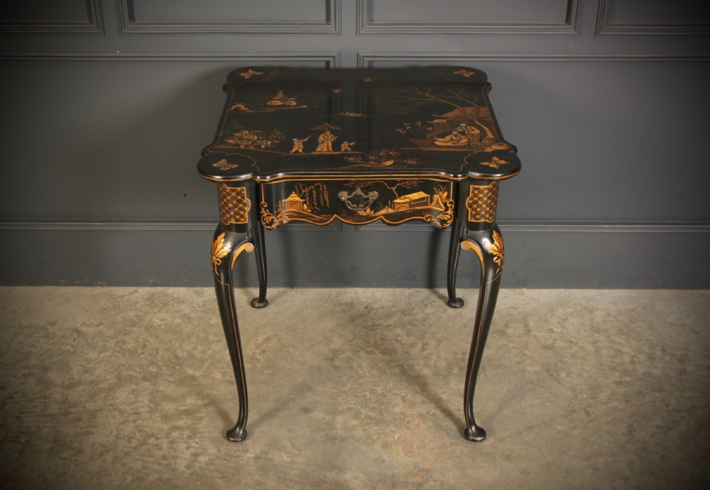 A black lacquered occasional table with gilded Chinoiserie scenes, a scalloped rim, and cabriole legs. View VII