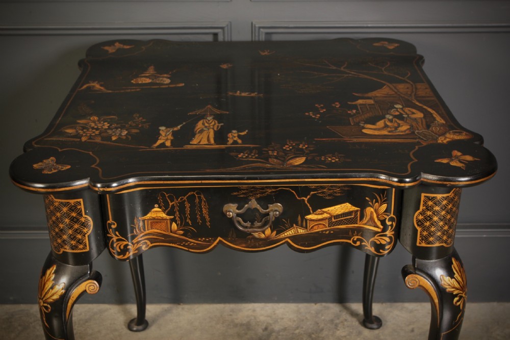 A black lacquered occasional table with gilded Chinoiserie scenes, a scalloped rim, and cabriole legs. View IX