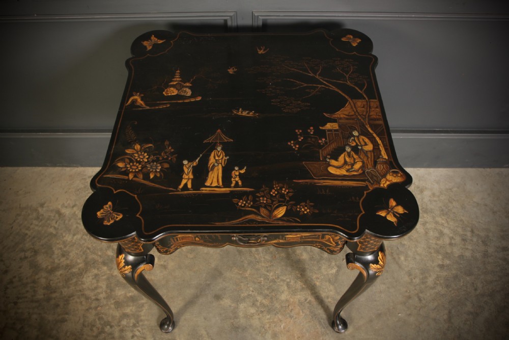 A black lacquered occasional table with gilded Chinoiserie scenes, a scalloped rim, and cabriole legs. View X