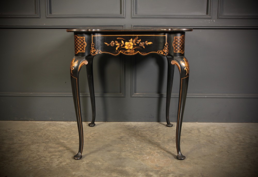 A black lacquered occasional table with gilded Chinoiserie scenes, a scalloped rim, and cabriole legs. View XIII