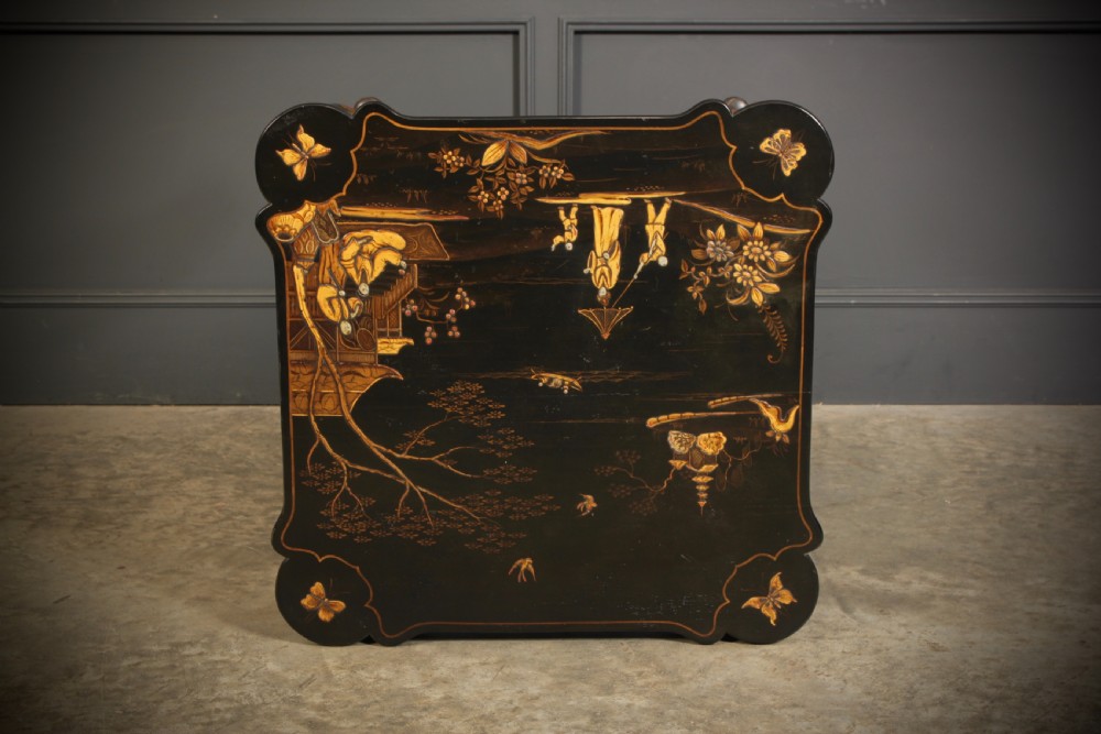 A black lacquered occasional table with gilded Chinoiserie scenes, a scalloped rim, and cabriole legs. View XV