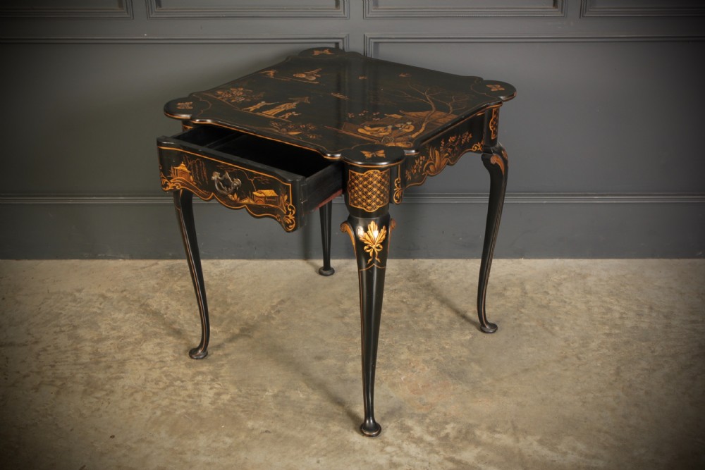 A black lacquered occasional table with gilded Chinoiserie scenes, a scalloped rim, and cabriole legs. View XVII