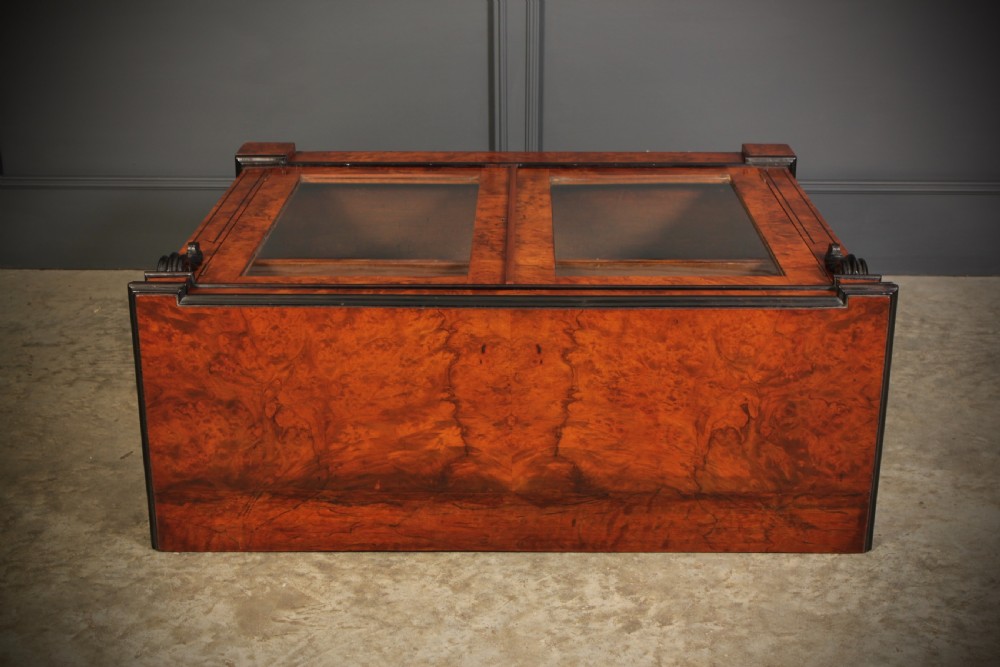 A low Victorian bookcase constructed from figured walnut wood featuring two glazed glass doors, black carved corbels, and internal timber shelves. View X