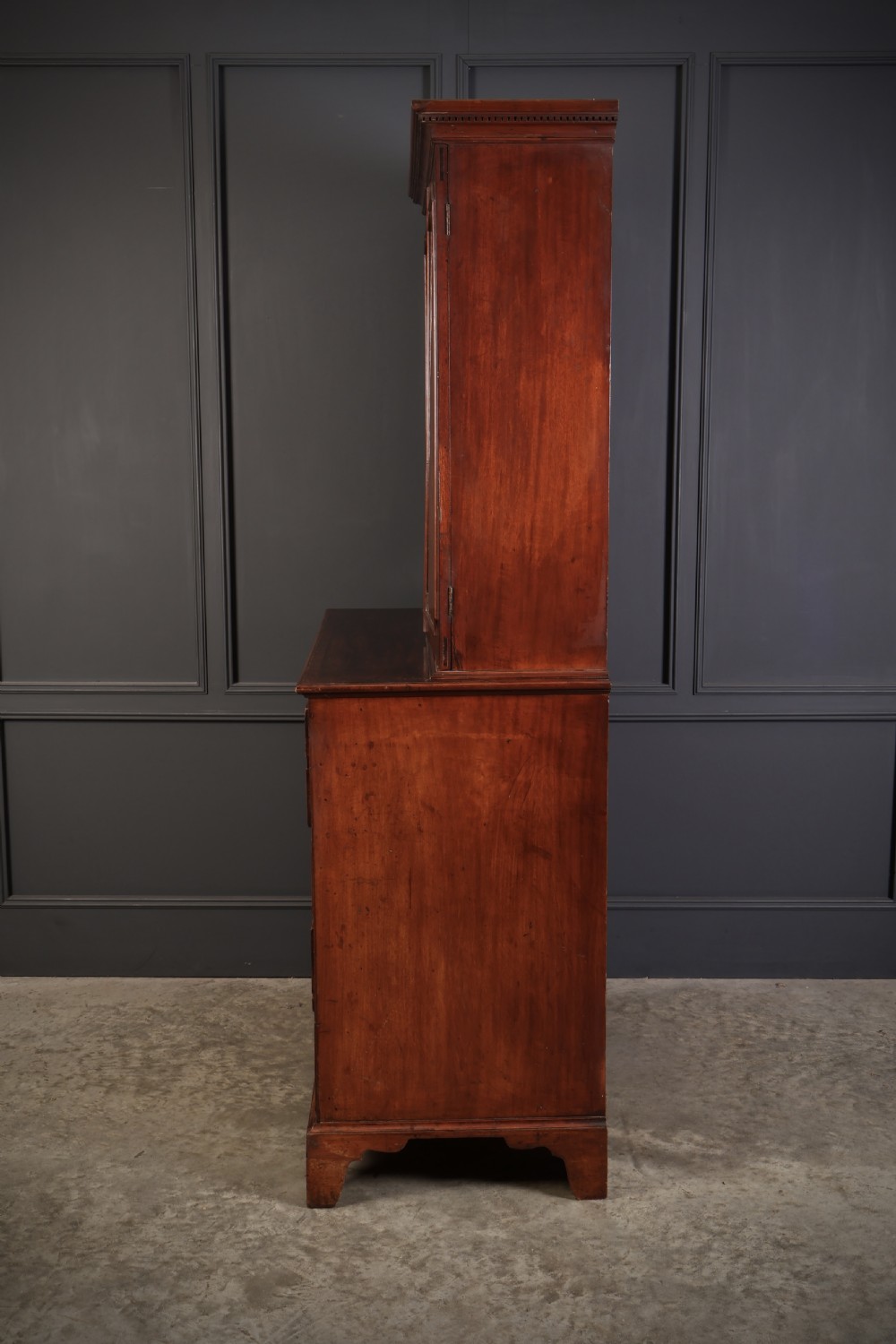 A George III mahogany secretaire cabinet featuring a twin panelled cupboard top over a lower chest of drawers with bracket feet. View VIII
