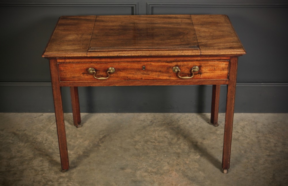 A Georgian mahogany architects table with a hinged adjustable writing slope top, a single drawer with brass swan-neck handles, and straight square legs fitted with brass castors. View VIII