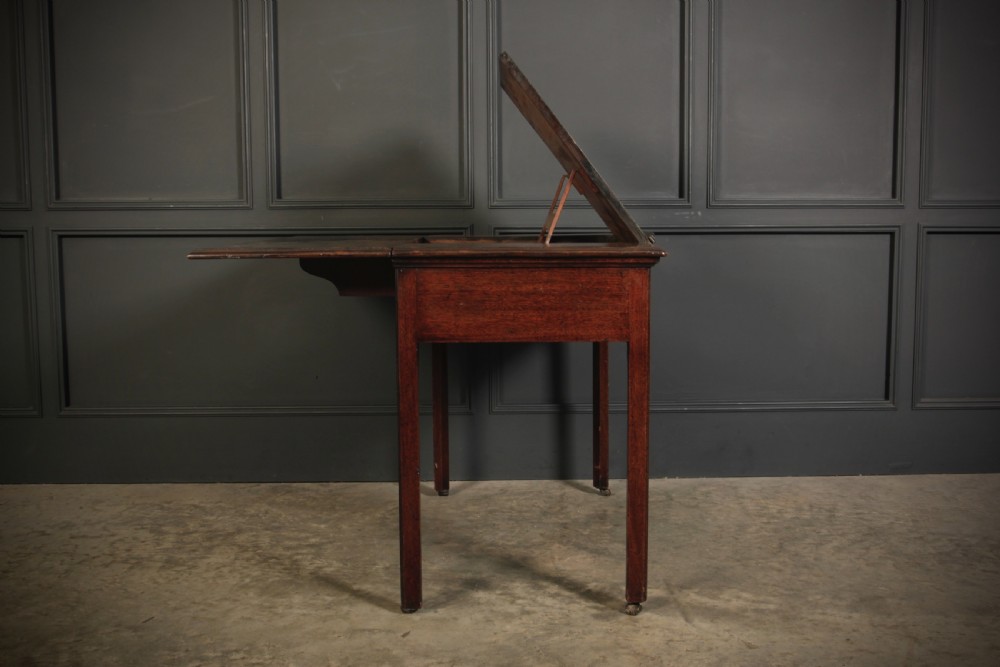A Georgian mahogany architects table with a hinged adjustable writing slope top, a single drawer with brass swan-neck handles, and straight square legs fitted with brass castors. View XI