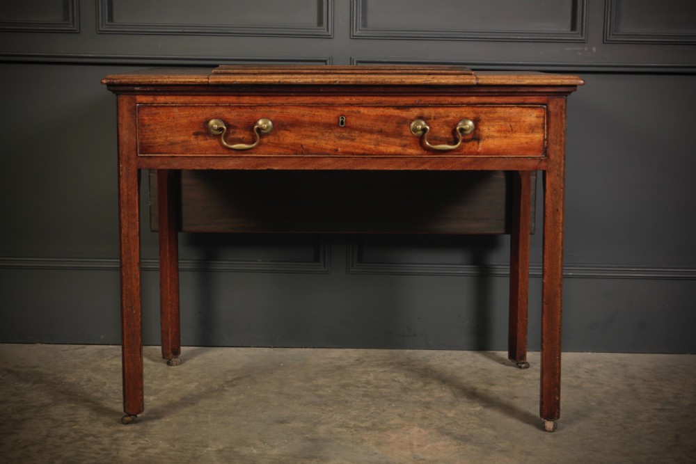 A Georgian mahogany architects table with a hinged adjustable writing slope top, a single drawer with brass swan-neck handles, and straight square legs fitted with brass castors. View XII