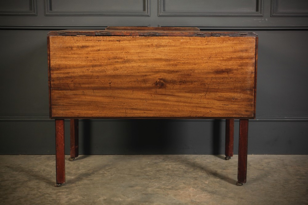 A Georgian mahogany architects table with a hinged adjustable writing slope top, a single drawer with brass swan-neck handles, and straight square legs fitted with brass castors. View XVI