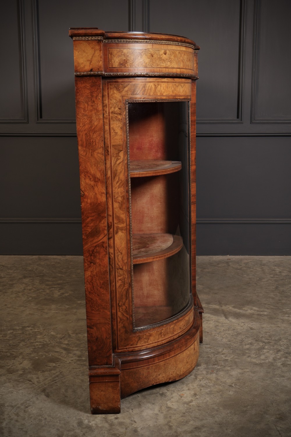 A nineteenth-century Victorian credenza made from burr walnut featuring central floral marquetry, curved glazed side display doors, and polished metal mounts. View XII