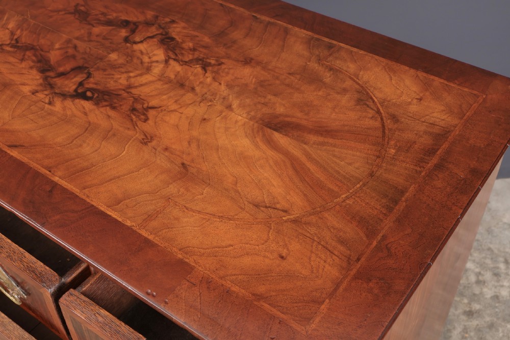 A Queen Anne style warm brown walnut chest of drawers featuring inlaid geometric top decoration, brass drop handles, keyhole escutcheons, and turned bun feet. View IX