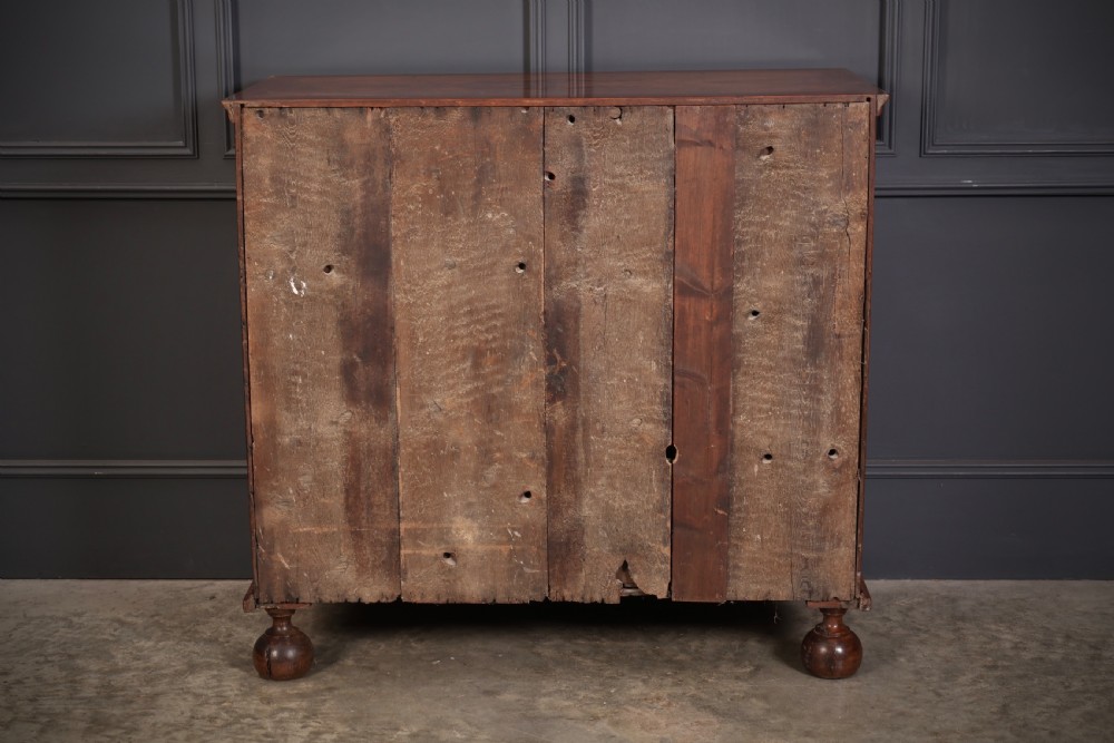 A Queen Anne style warm brown walnut chest of drawers featuring inlaid geometric top decoration, brass drop handles, keyhole escutcheons, and turned bun feet. View XIII
