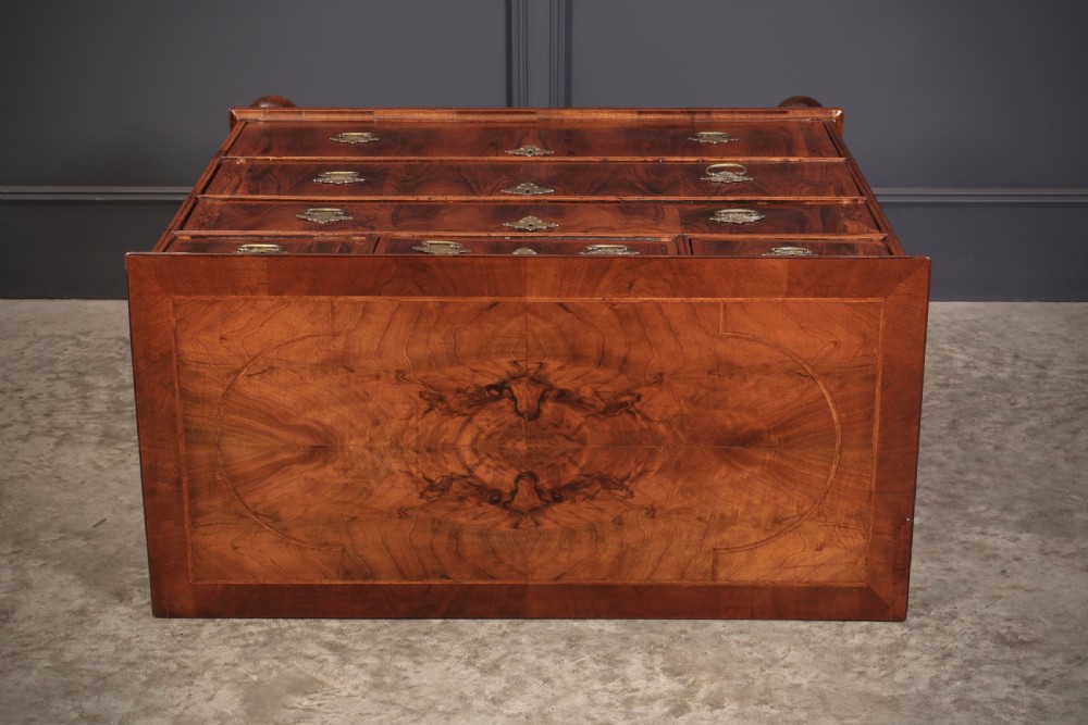 A Queen Anne style warm brown walnut chest of drawers featuring inlaid geometric top decoration, brass drop handles, keyhole escutcheons, and turned bun feet. View XIV