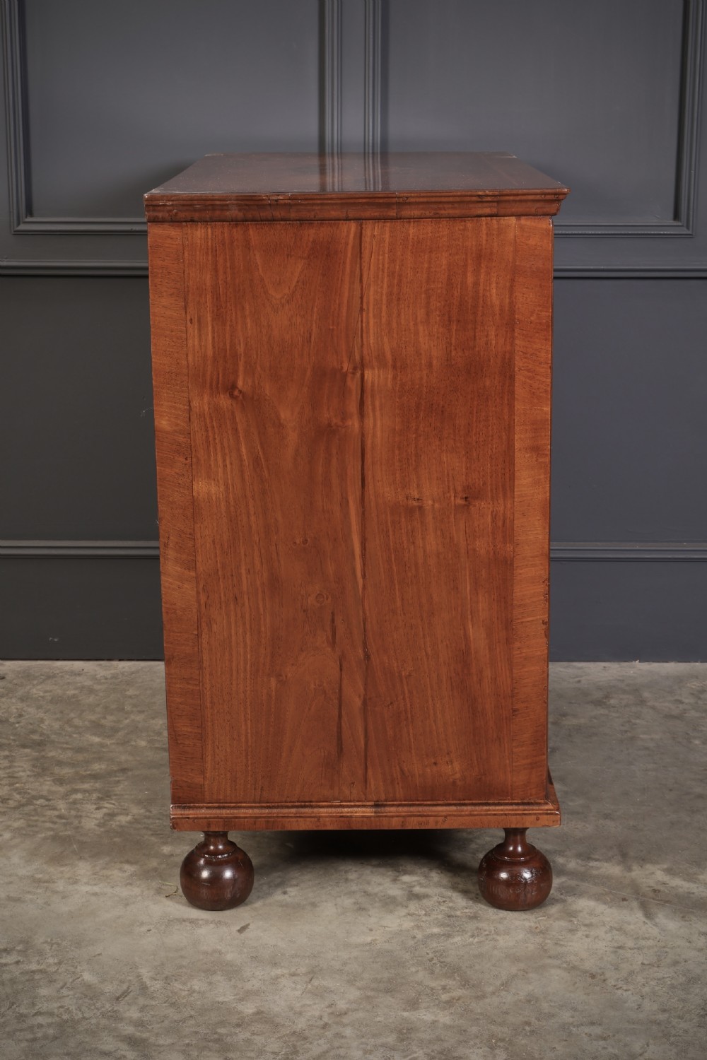 A Queen Anne style warm brown walnut chest of drawers featuring inlaid geometric top decoration, brass drop handles, keyhole escutcheons, and turned bun feet. View XV