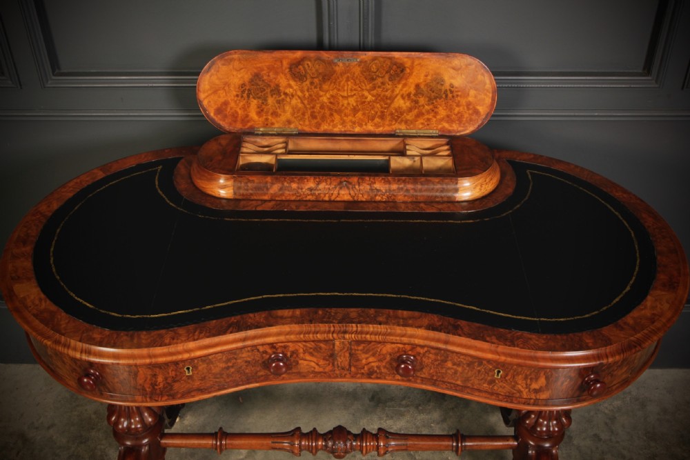 A Victorian burr walnut kidney-shaped writing table featuring a black leather insert, inlaid marquetry, raised caddy, frieze drawers, and carved legs on castors. View III