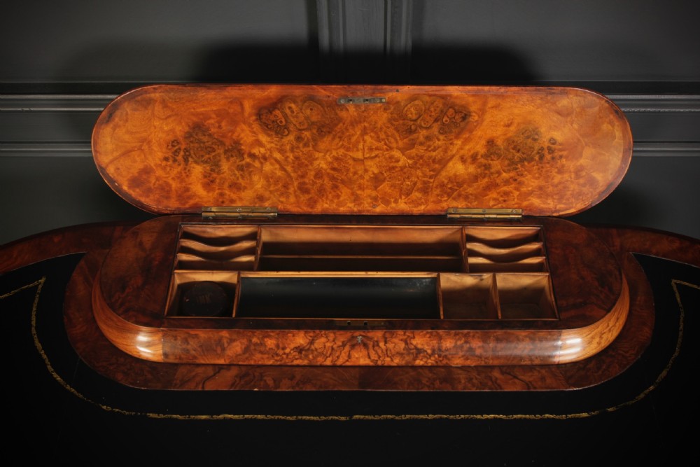 A Victorian burr walnut kidney-shaped writing table featuring a black leather insert, inlaid marquetry, raised caddy, frieze drawers, and carved legs on castors. View V