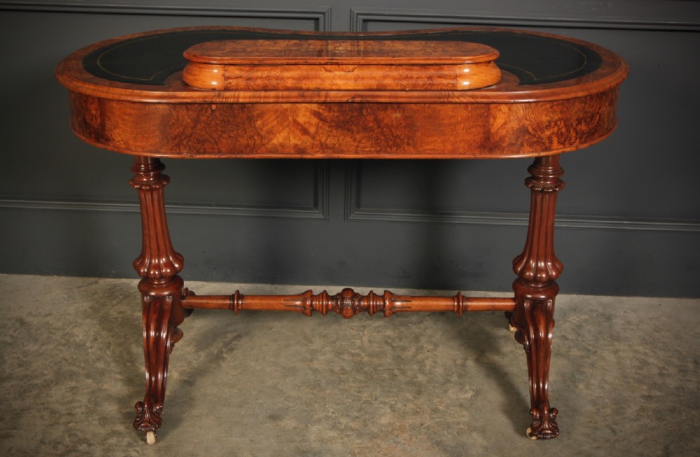 A Victorian burr walnut kidney-shaped writing table featuring a black leather insert, inlaid marquetry, raised caddy, frieze drawers, and carved legs on castors. View XIII