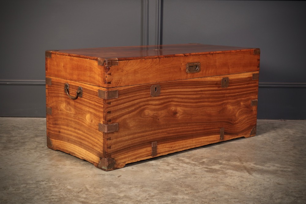 An antique camphor wood military campaign trunk with protective brass corner straps, flush brass fittings, and side carrying handles. View II