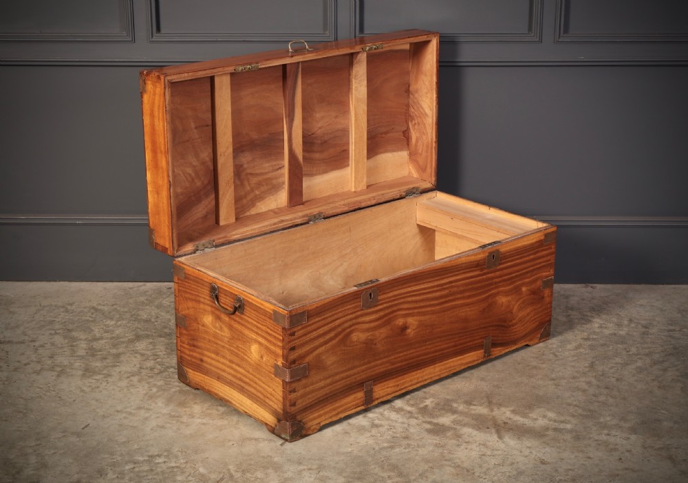 An antique camphor wood military campaign trunk with protective brass corner straps, flush brass fittings, and side carrying handles. View III