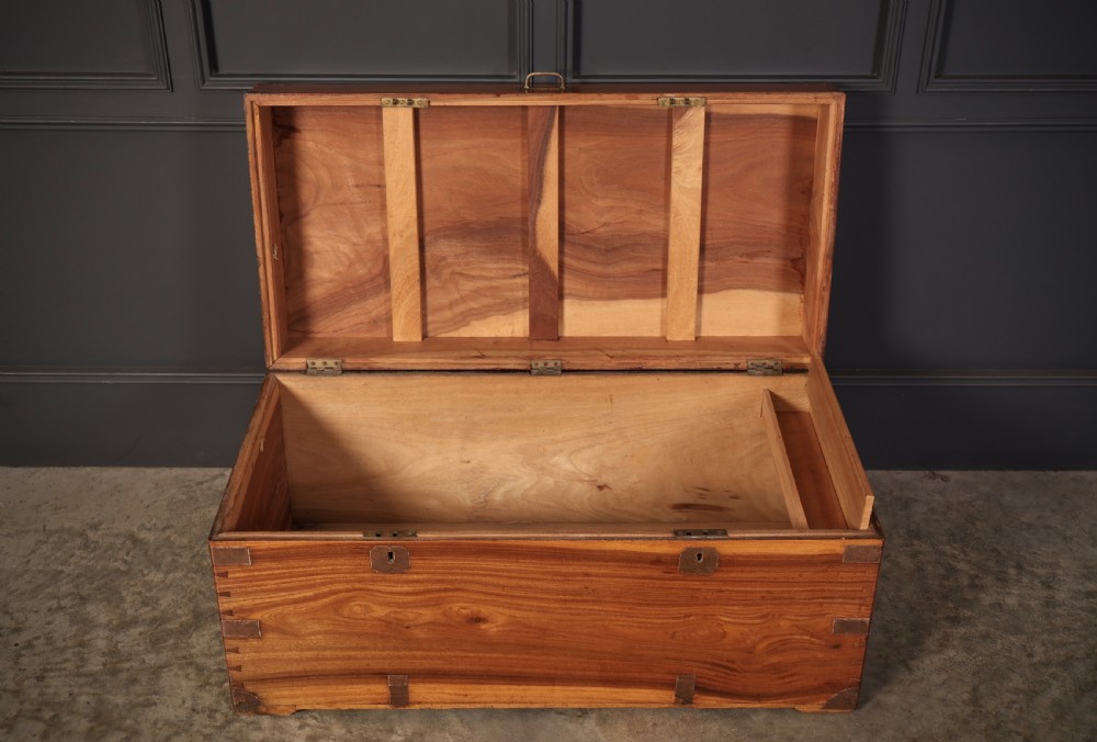An antique camphor wood military campaign trunk with protective brass corner straps, flush brass fittings, and side carrying handles. View VII
