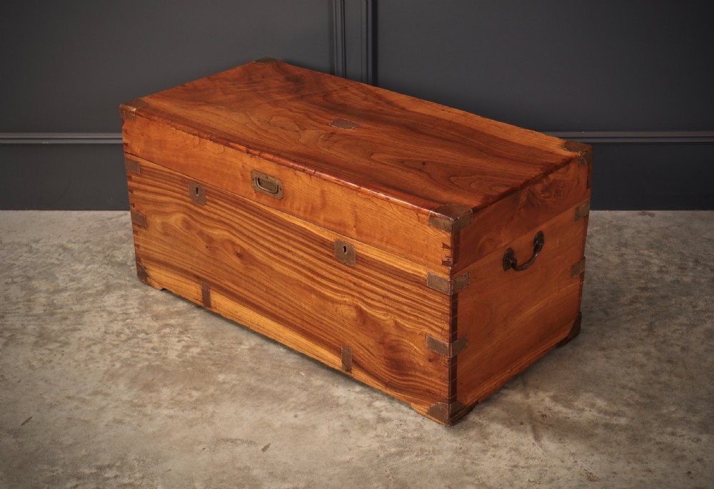An antique camphor wood military campaign trunk with protective brass corner straps, flush brass fittings, and side carrying handles. View VIII