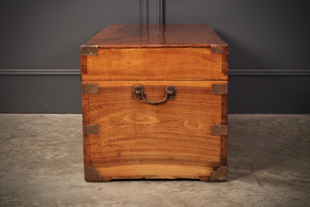 An antique camphor wood military campaign trunk with protective brass corner straps, flush brass fittings, and side carrying handles. View XI