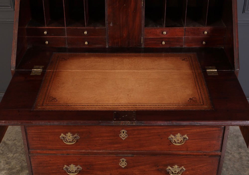A Georgian rich mahogany bureau bookcase featuring a two-door upper cabinet, slant-front writing bureau, four drawers with brass handles, and bracket feet. View III