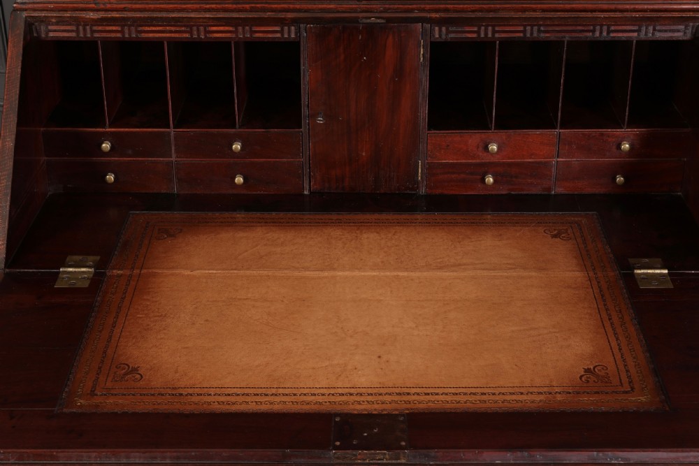 A Georgian rich mahogany bureau bookcase featuring a two-door upper cabinet, slant-front writing bureau, four drawers with brass handles, and bracket feet. View VI