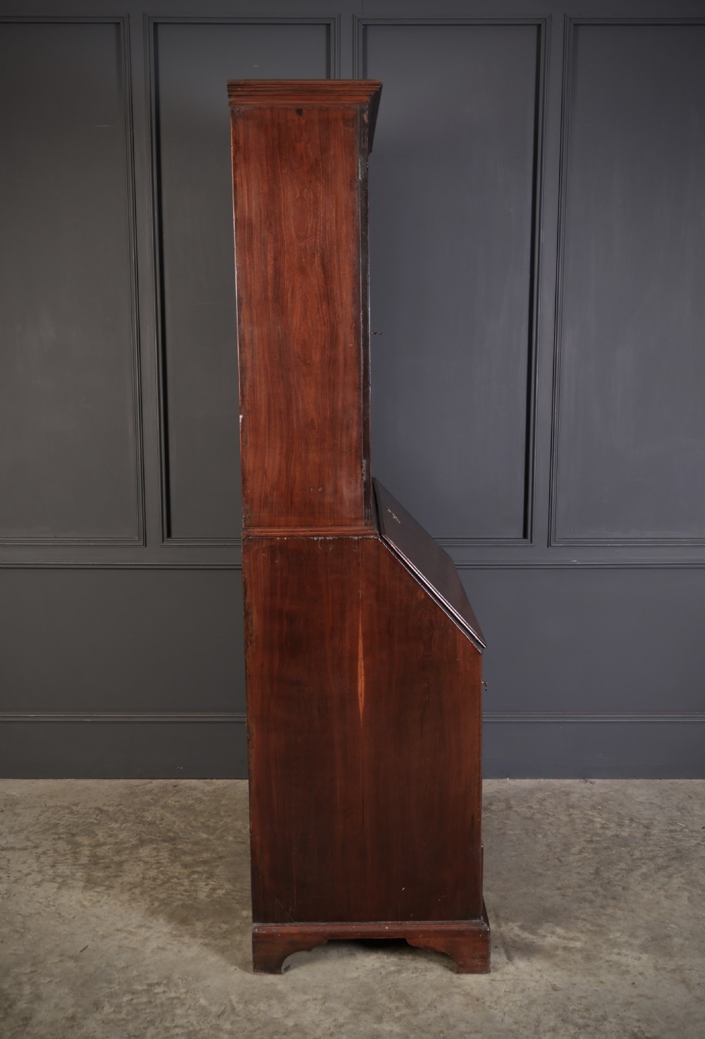 A Georgian rich mahogany bureau bookcase featuring a two-door upper cabinet, slant-front writing bureau, four drawers with brass handles, and bracket feet. View XIII