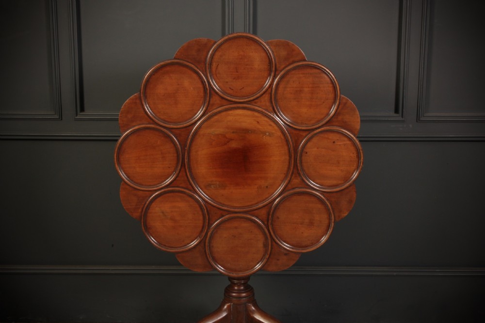 An 18th-century Georgian mahogany supper table with a scalloped dished top mounted on a turned pedestal stem with three cabriole legs. View V