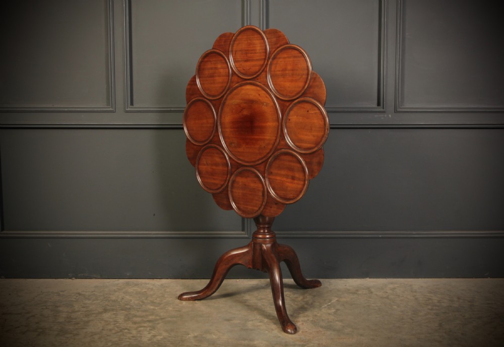 An 18th-century Georgian mahogany supper table with a scalloped dished top mounted on a turned pedestal stem with three cabriole legs. View VI