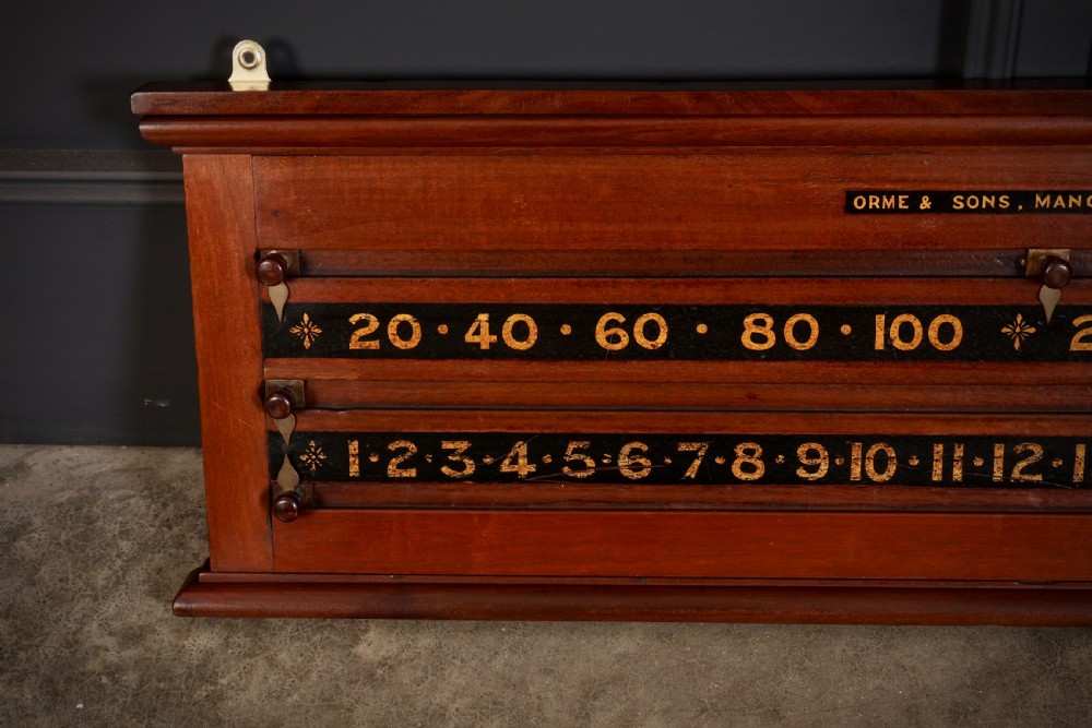 A wall-mounted Victorian mahogany snooker scoreboard featuring brass sliding pointers and gilded numerals set against black painted tracks. View II