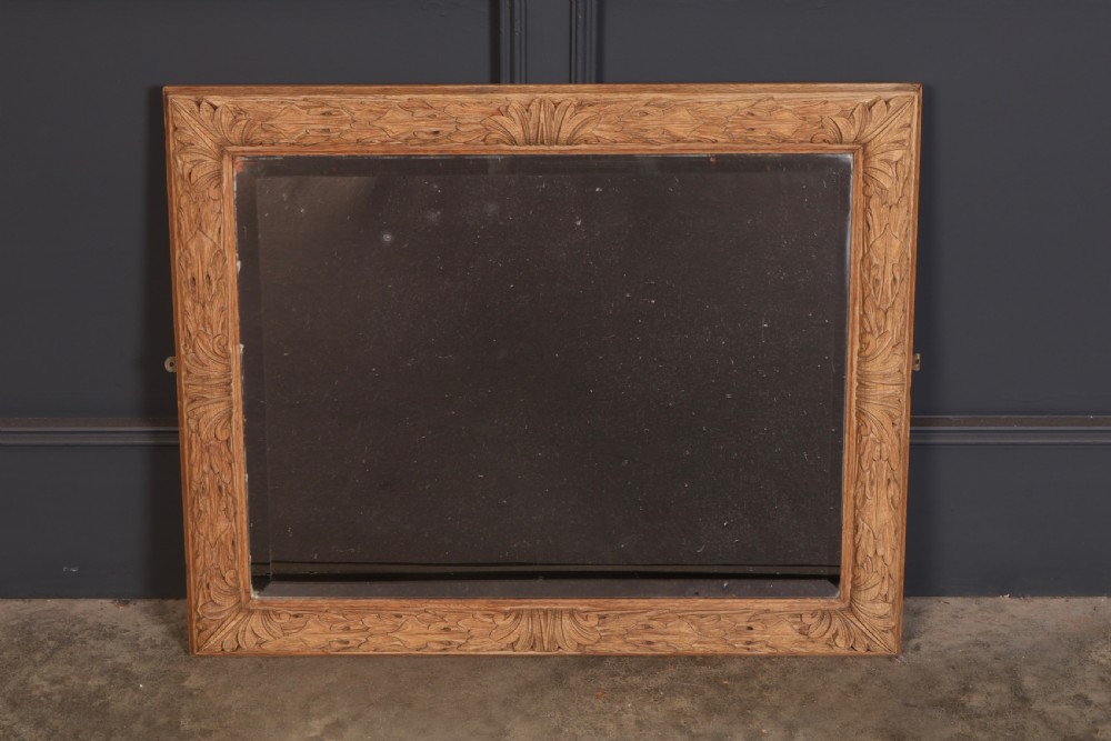 A rectangular wall mirror featuring a carved oak frame with relief acanthus leaf motifs surrounding a central reflective glass panel. View II