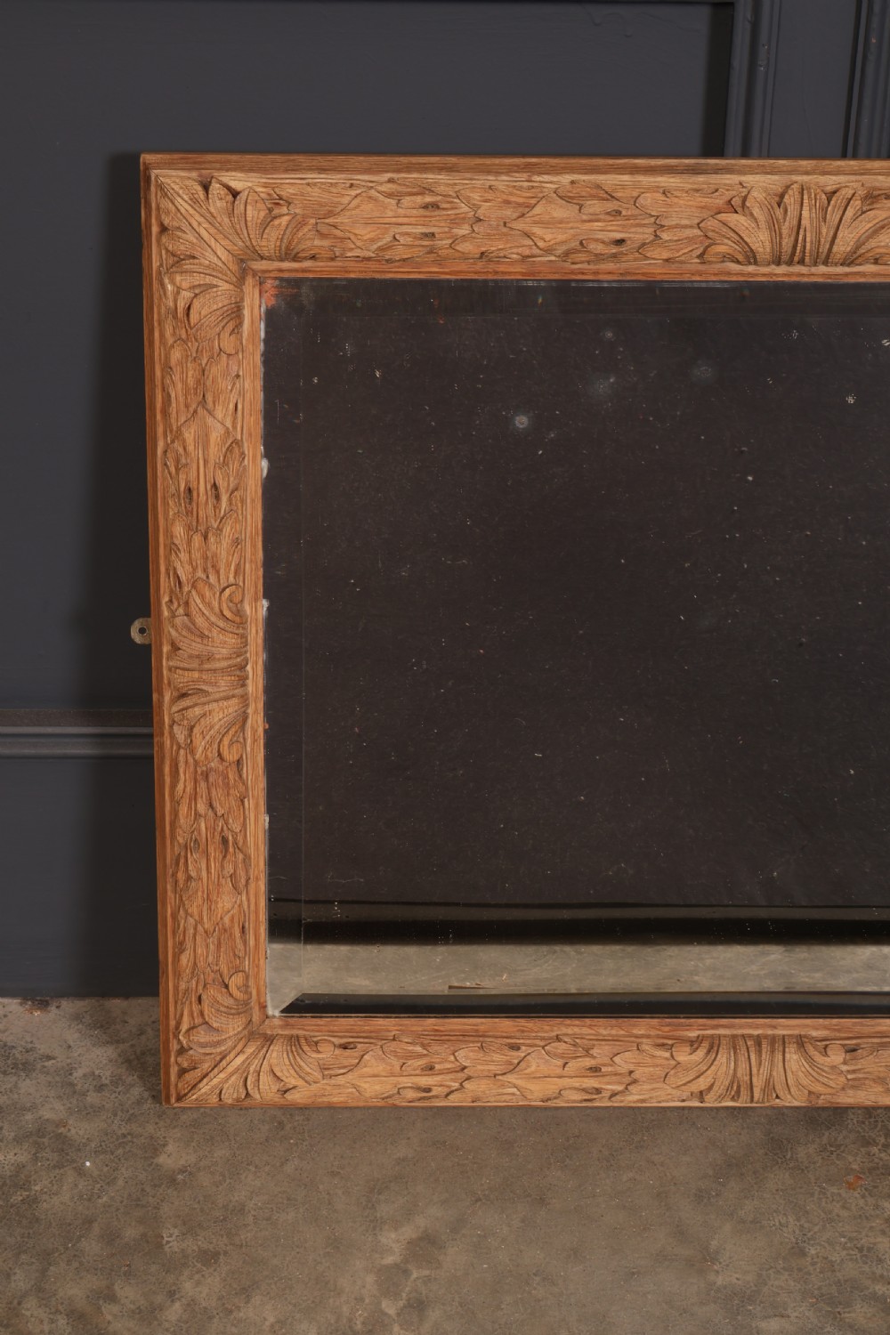 A rectangular wall mirror featuring a carved oak frame with relief acanthus leaf motifs surrounding a central reflective glass panel. View III