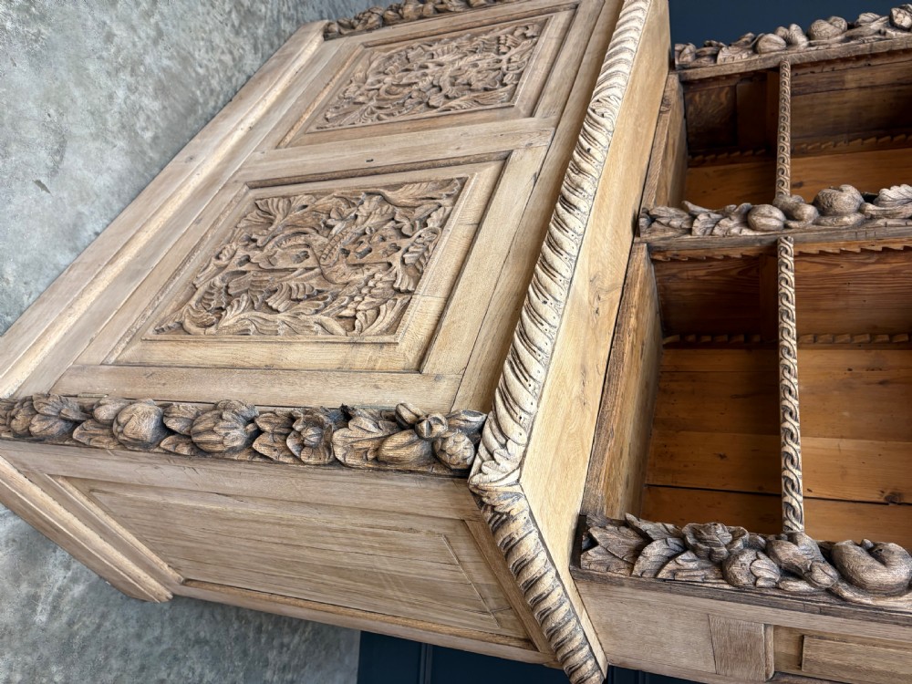 A large two-tier bleached oak open bookcase featuring heavily carved floral pilasters, open adjustable shelves, and a lower cabinet with relief-carved doors. View VI