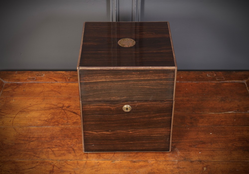A Victorian coromandel wood decanter box lined with purple velvet, containing four square cut-glass decanters with faceted square stoppers. View V