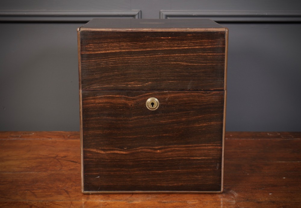 A Victorian coromandel wood decanter box lined with purple velvet, containing four square cut-glass decanters with faceted square stoppers. View VII