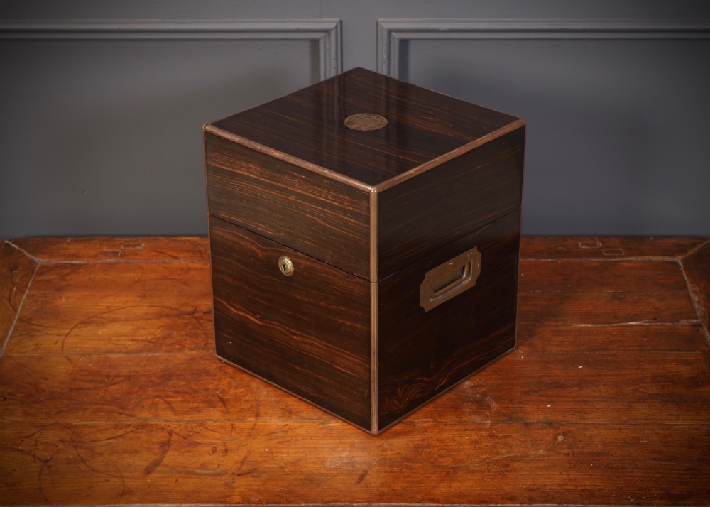 A Victorian coromandel wood decanter box lined with purple velvet, containing four square cut-glass decanters with faceted square stoppers. View VIII