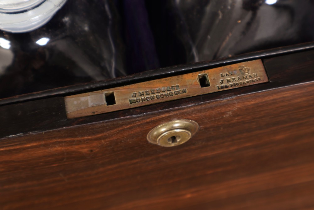A Victorian coromandel wood decanter box lined with purple velvet, containing four square cut-glass decanters with faceted square stoppers. View XII